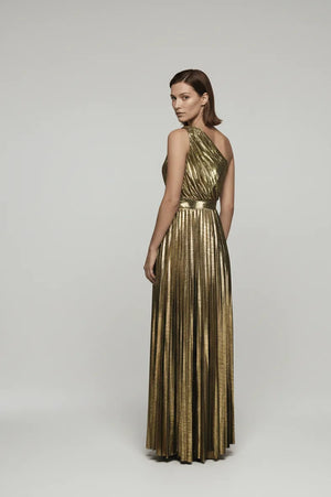 Woman wearing a gold pleated dress on a gray background