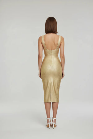 Woman wearing a gold dress with a backless design on a white background