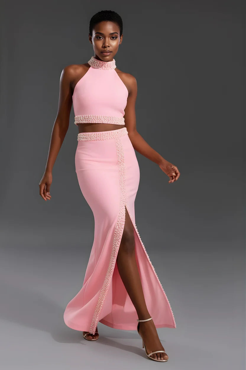 Model wearing a pink two-piece outfit with a high slit on a gray background