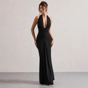 Woman wearing a black halter neck gown against a plain background