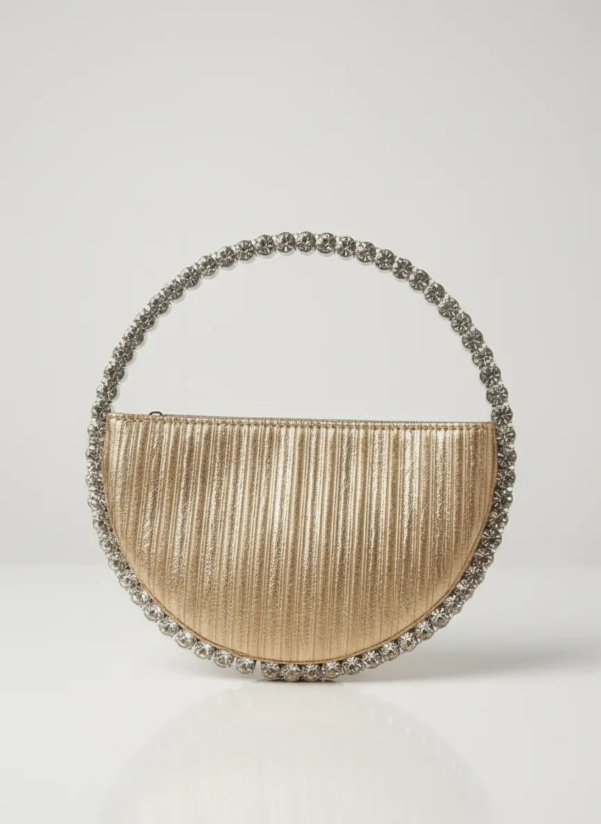 Gold handbag with decorative handle on a light gray background