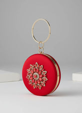 Red round clutch with floral embellishments on a gray background