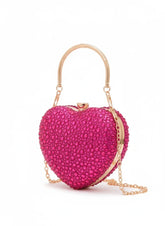 Pink heart-shaped clutch bag with gold chain on a white background