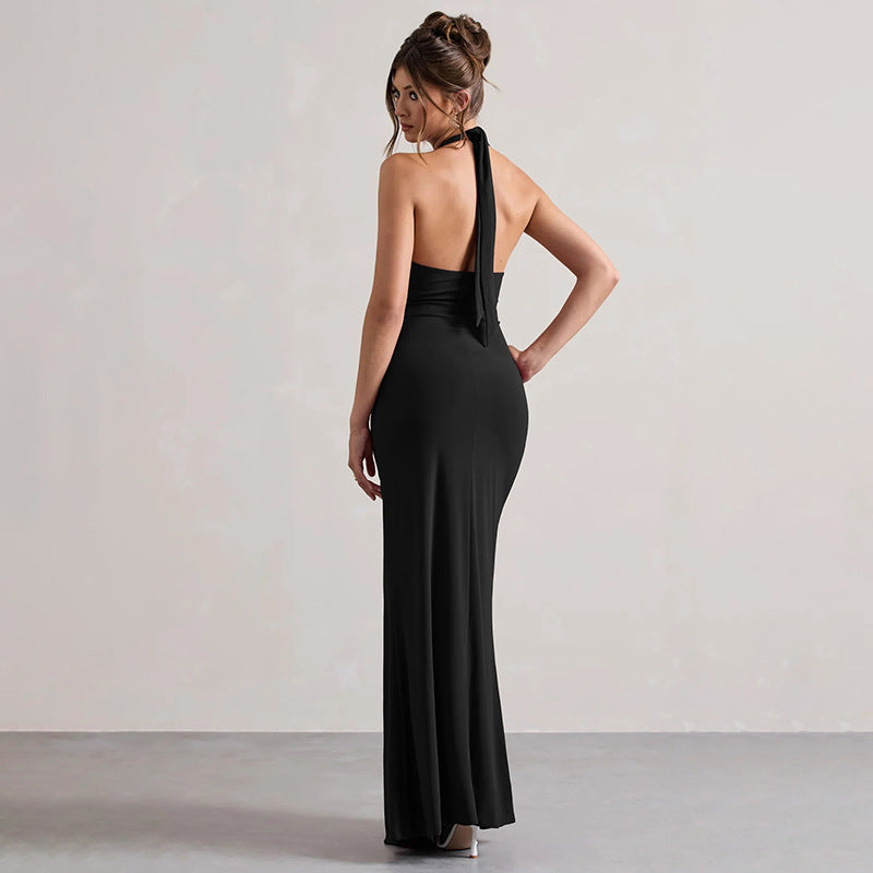 Woman wearing a black one-shoulder evening gown against a plain background