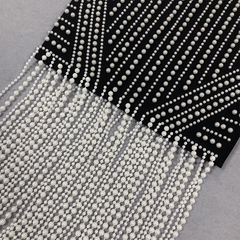 Black fabric with white pearl-like beads on a gray background