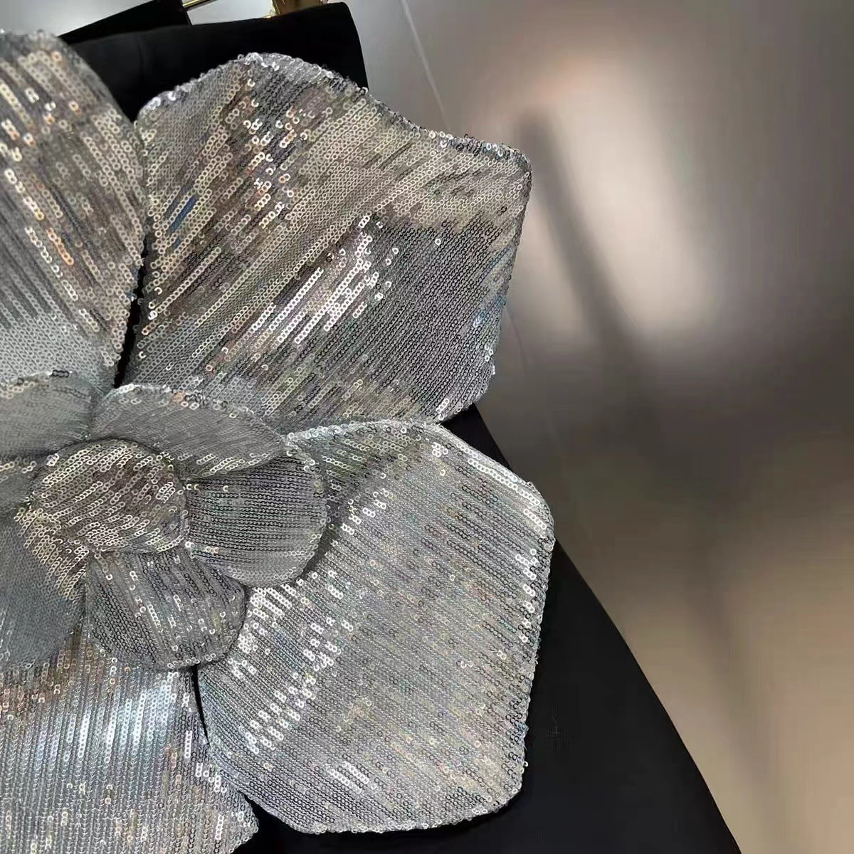 Close-up of a silver sequin flower on a black background
