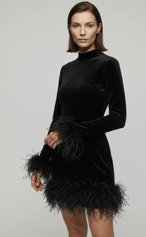 Woman wearing a black velvet dress with feather details on a gray background