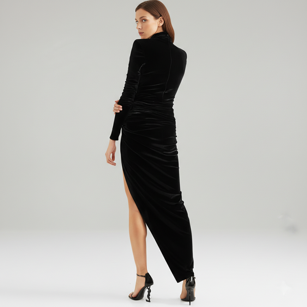 Woman wearing a black velvet dress with a high slit on a gray background