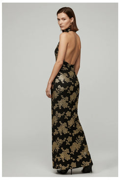 Woman wearing a black floral evening gown on a gray background