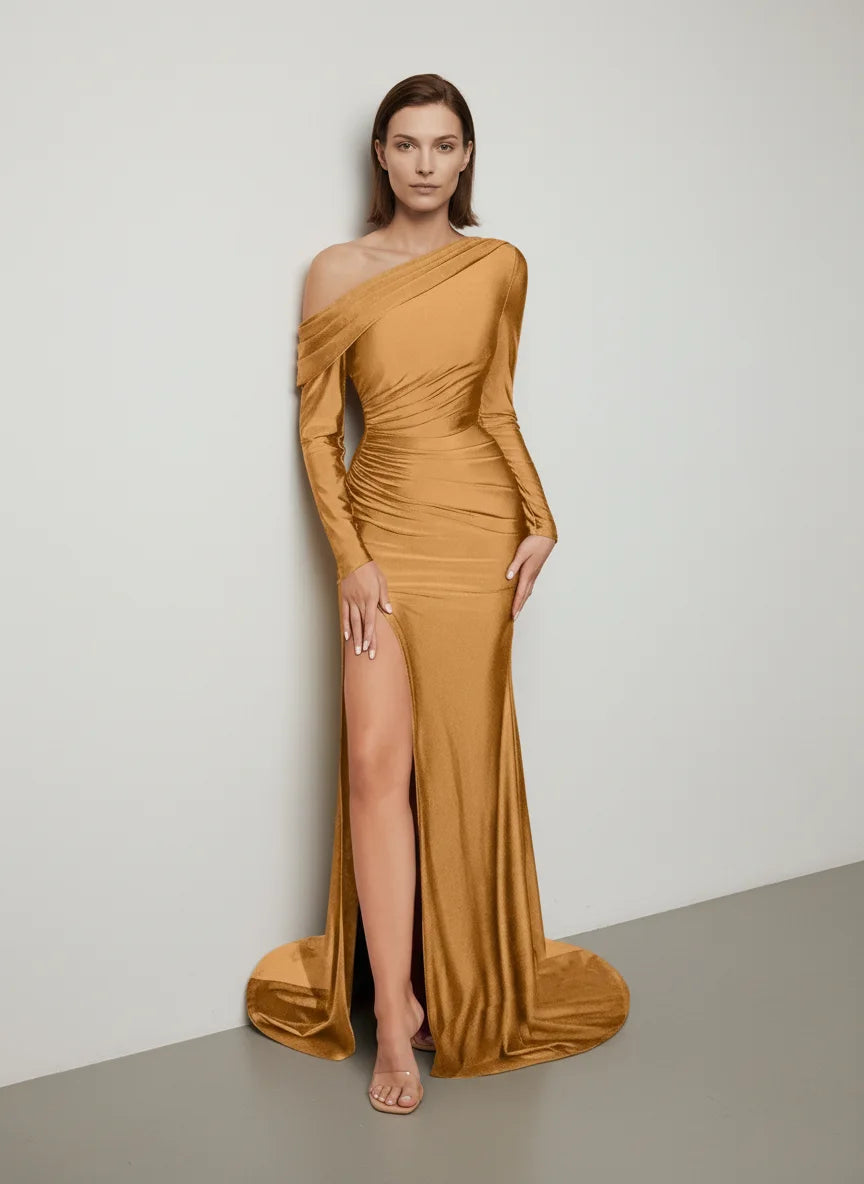 Woman wearing a mustard yellow one-shoulder dress with a high slit on a plain background
