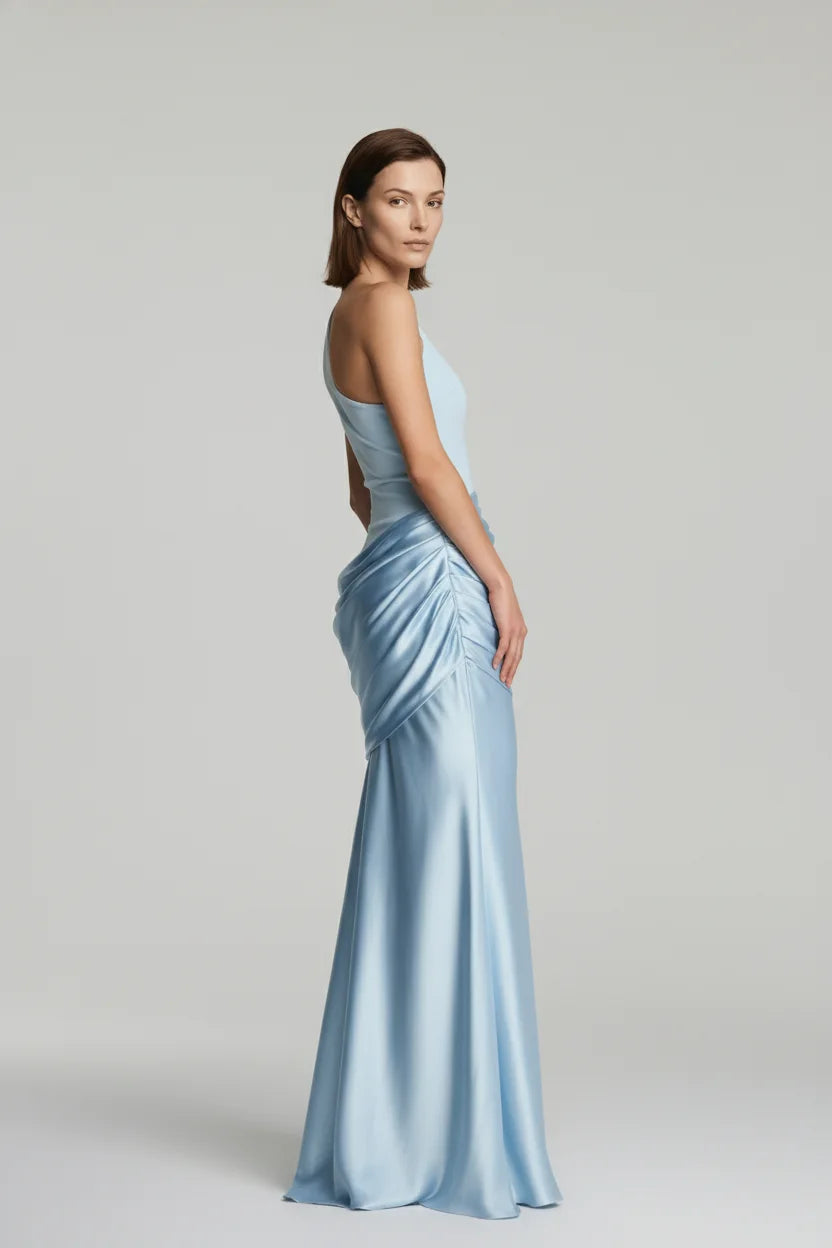Woman wearing a light blue evening gown on a plain background