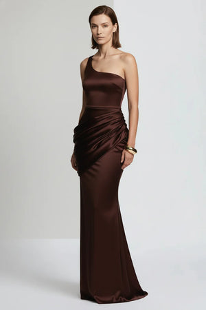 Woman wearing a brown one-shoulder evening gown on a white background
