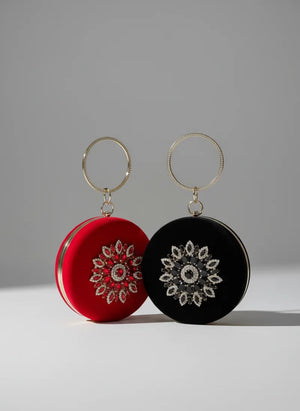 Two round earrings, one red and one black, with intricate patterns on a gray background.