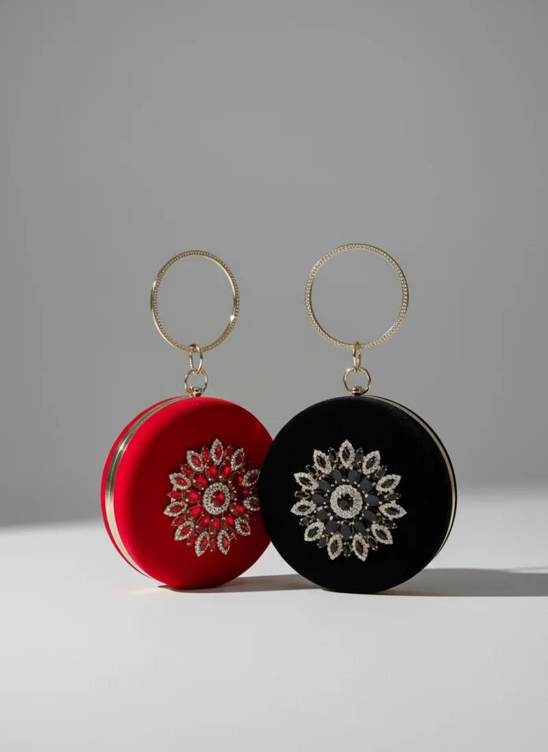 Two round earrings, one red and one black, with intricate patterns on a gray background.