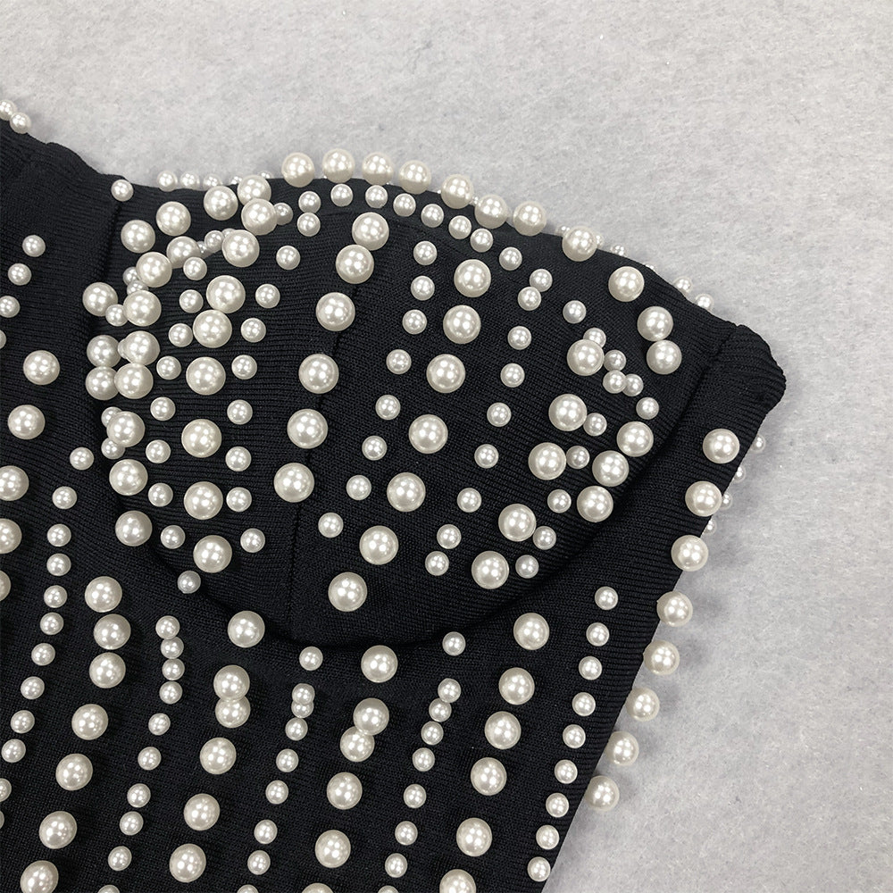 Black fabric with white pearl-like beads on a gray background