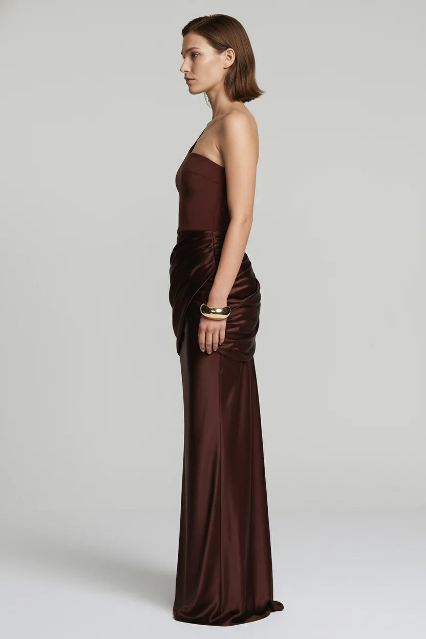 Woman wearing a brown strapless gown on a plain background
