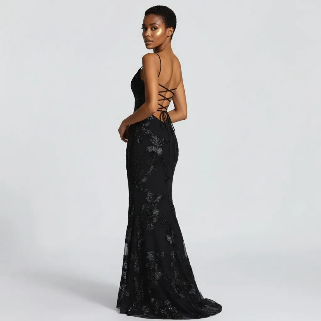Woman wearing a black lace evening gown with a white background