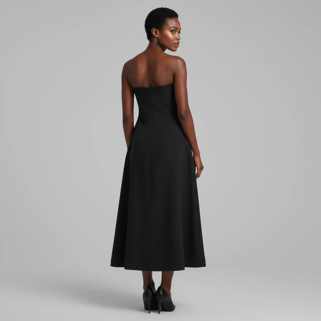 Woman wearing a black strapless dress against a gray background