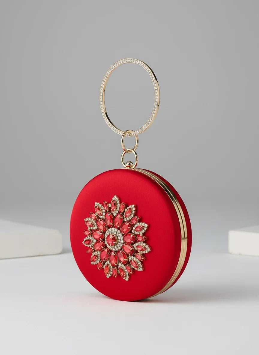 Red round clutch with floral embellishments on a gray background