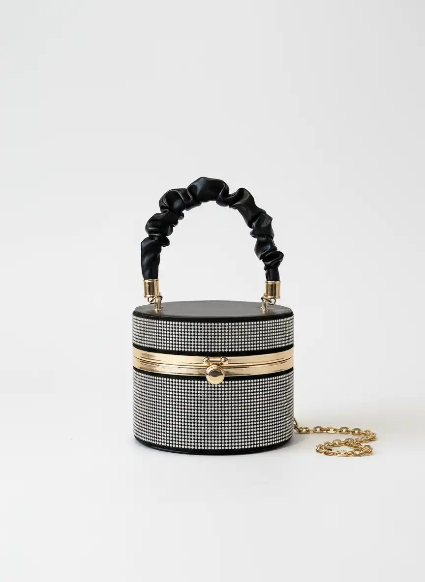 Black and white patterned handbag with a chain detail on a white background