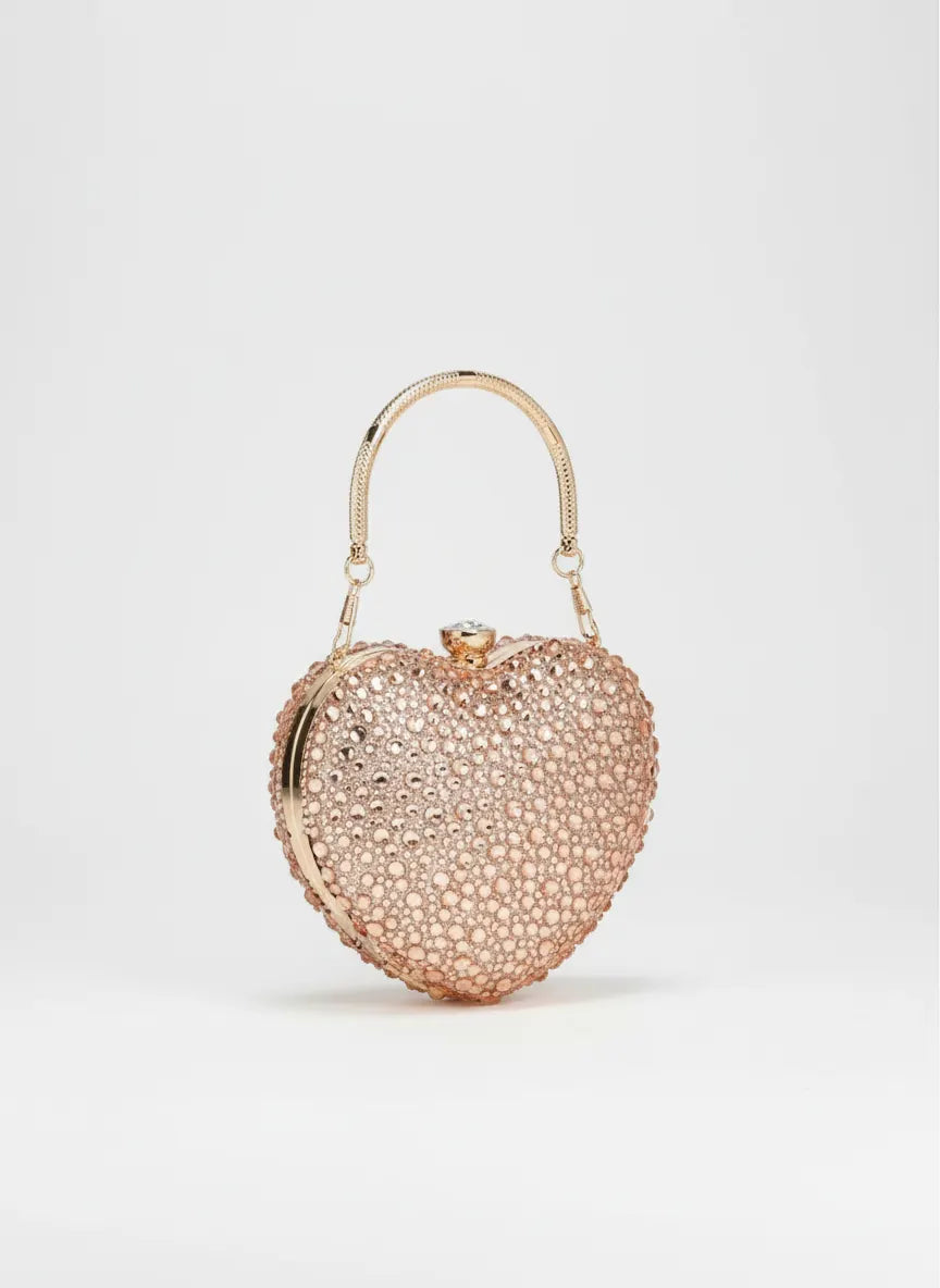 Heart-shaped clutch bag with rhinestone embellishments on a light gray background