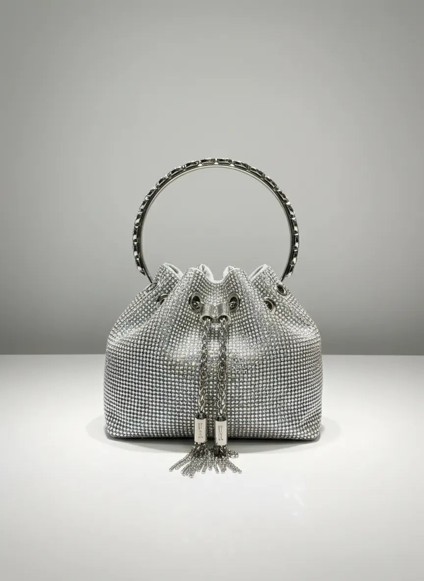 Silver beaded handbag with tassels on a gray background
