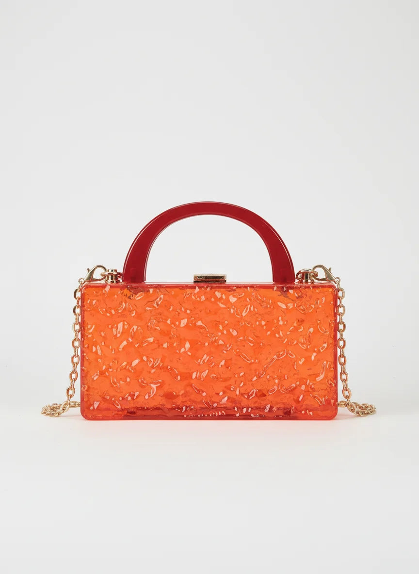 Orange handbag with a red handle on a white background